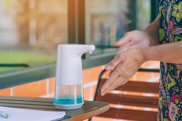 Automatic alcohol dispenser for cleaning hand to prevent the spreading of Coronavirus (Covid-19) on table before entrance to cafeteria. Healthcare concept. New normal lifestyle. Selective focus