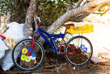 Old colored bicycle parked near a tree. Typical life in Africa.