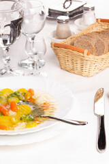 Plate with fresh hot soup on the table and homemade buns