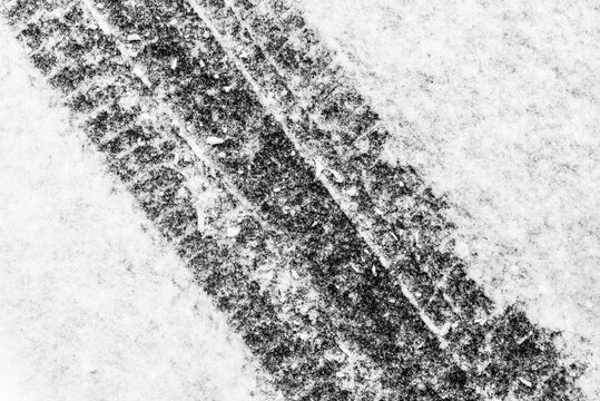 Trace of car tires in the fresh snow. Close up view from above