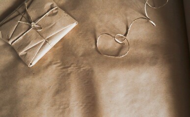 The package is wrapped in kraft paper and tied with thread