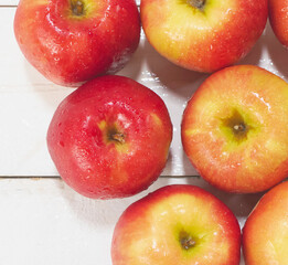 Top view of apples with water drops around put on wooden board,