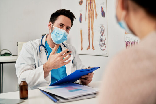Doctor in protective mask talking with a patient in the office, Poland, podkarpackie, D&fnof;&ocirc;bica