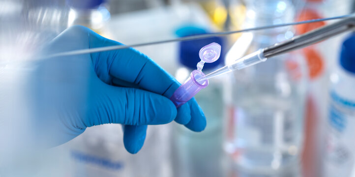Male scientist pipetting chemical formula into vial in laboratory