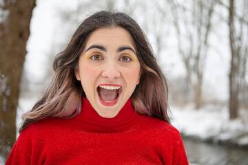 Playful woman with mouth open during winter