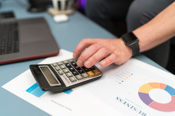 Businessman using calculator while working at home