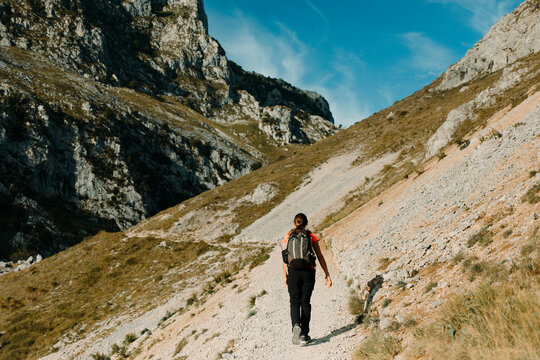 Woman with backpack hiking on Cares Trail at Picos De Europe National Park, Asturias, Spain