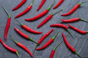 Several fresh Red hot chili pepper on a dark black stone background, food ingredient concept, top...