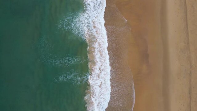 Professional Video. Aerial view Nature video. Powerful stormy sea waves in top-down drone shot perspective. Crashing wave line in Phuket South of Thailand. Andaman sea with foamy white texture.