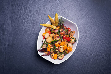 Gourmet vegetable salad on wooden table in sunny day. Restaurant diet menu. Concept of healthy food