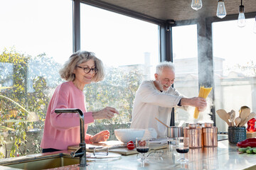 Senior couple cooking together in kitchen at home