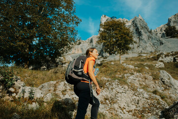 Female hiker wearing backpack hiking on Cares Trail at Picos De Europe National Park, Asturias, Spain