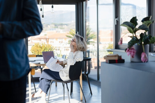 Man standing with thoughtful woman in background at home