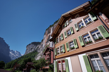 Traditional swiss village. Beautiful landscape with houses against Alps Mountains.