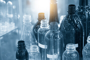 The various type of plastic bottles with lighting effect. The PET bottle container manufacturing process concept.