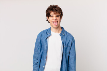 young handsome man with cheerful and rebellious attitude, joking and sticking tongue out