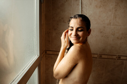 Portrait of adult woman smiling while taking shower