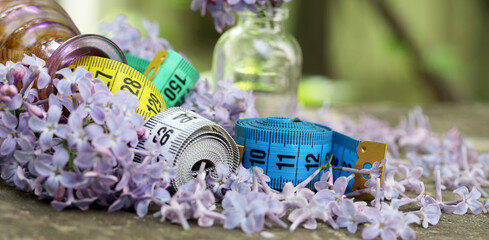 concept with measuring tape with lilac flowers in the garden