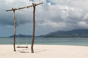 Obraz na płótnie Canvas The wooden swing on the beach.