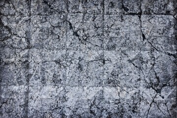 Cracked old concrete wall texture. Broken rough cement surface. Dark gray gloomy grunge abstract background
