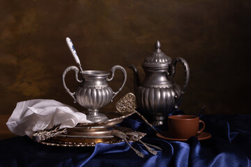 Still life with vintage pewter and blue silk