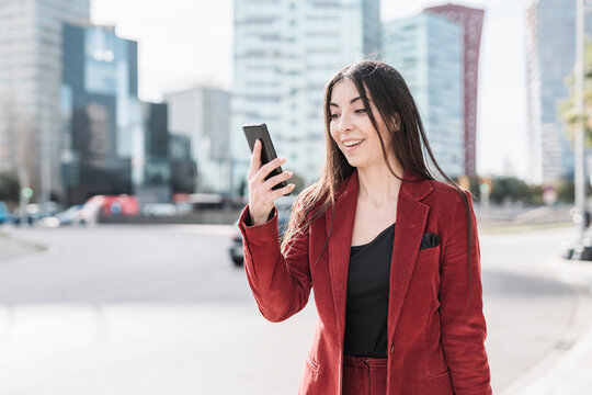 Surprised businesswoman looking at smart phone while standing in city