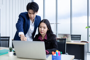 Stressed Business partners tomboy lesbian and business female working and  business plan on the laptop computer In the office room background.