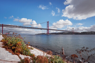 Beautiful landscape with suspension 25 April bridge bridge over the Tagus river in Lisbon, Portugal.