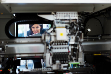 Female entrepreneur examining machinery at factory