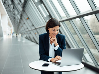 Female professional working on laptop in corridor
