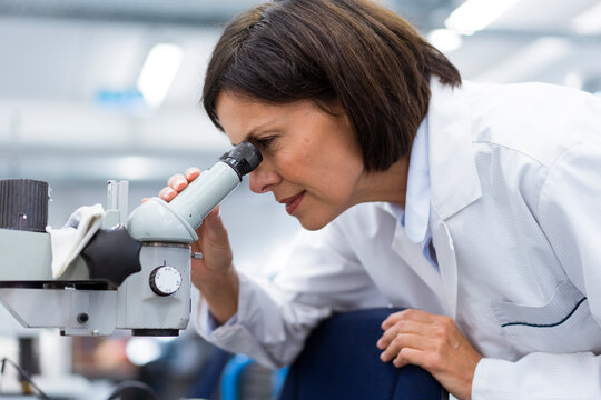 Female scientist using microscope while working in laboratory