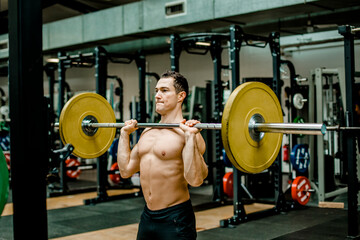 Strong man doing weightlifting exercise at gym