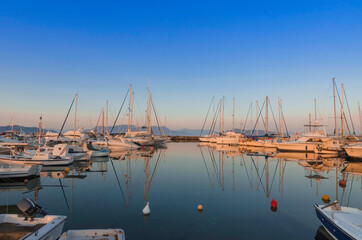Fototapeta premium Port of charming Aegina town with yachts and sail boats docked in Aegina island, Saronic gulf, Greece, at sunset.
