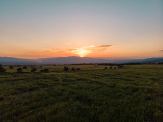 Aerial shot of a beautiful sunset over a grass area