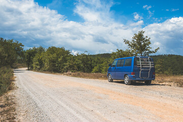 Fototapeta na wymiar Camping adventure in the wilderness: Minivan is standing at the side of the desert road