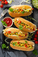 Hot dogs with mustard and letuce toping on a dark background. Homemade lifestyle hot dogs sandwiches
