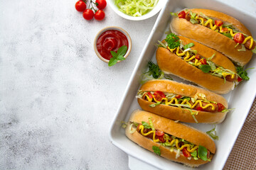 Homemade hot dogs with mustard and letuce toping on a bright background.