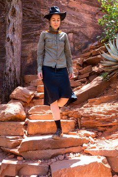 Female hiker walking down on red rocks, Sedona, Arizona, USA
