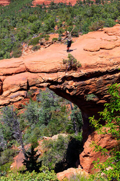 Female hiker dancing on Devil's Bridge Trailhead during sunny day, Sedona, Arizona, USA
