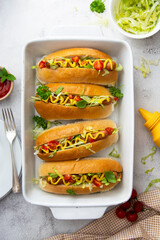 Homemade hot dogs with mustard and letuce toping on a bright background.