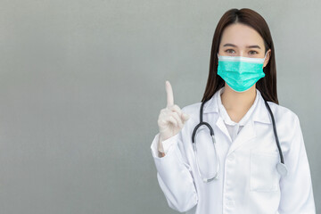 Woman doctor wearing medical face mask showing sign