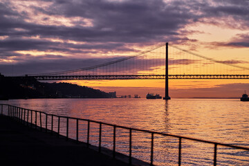 Fototapeta na wymiar Beautiful landscape with suspension 25 April bridge bridge over the Tagus river in Lisbon at sunset.
