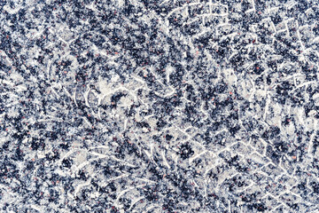 Multiple traces of car tires in the snow on the asphalt. Close up view from above