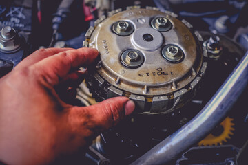 Close-up of motorcycle engine clutch system in maintenance checks.