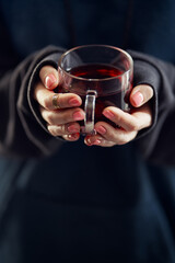 Cozy home. Female hands holding hot cup of tea.