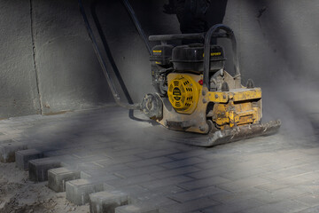 Obraz premium Press-for tamping tiles on sidewalks.