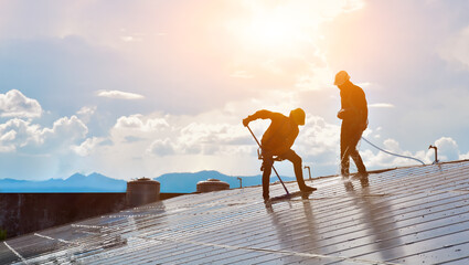 Solar roof technicians were washing and cleaning the surface of the solar panels  with water, brush...