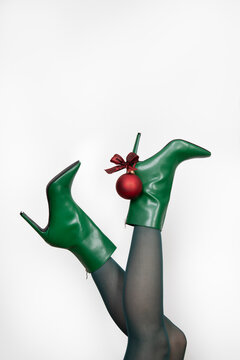 Woman in green colored stilettos with bauble against white background