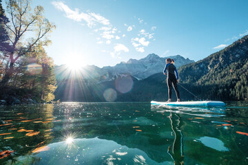 Germany, Bavaria, Garmisch Partenkirchen, Young woman stand up paddling on Lake Eibsee