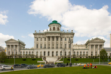 panoramic view of the white historical palace of the Peshkov House and passing cars against the background of a cloudy sky on a spring day. Concept-a famous place in Moscow Russia